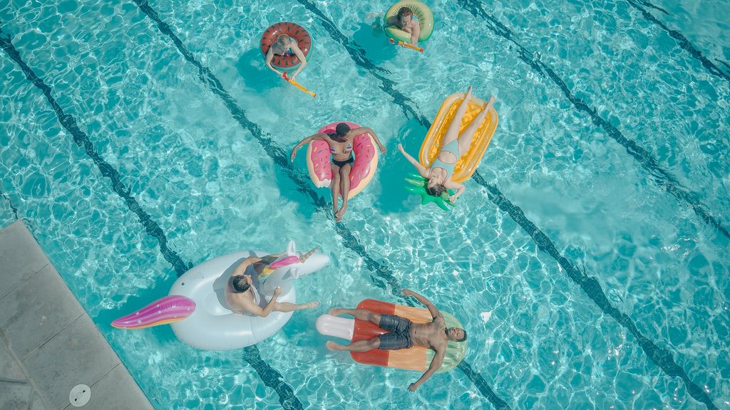 A vibrant aerial view of friends enjoying a pool party with fun floaties.
