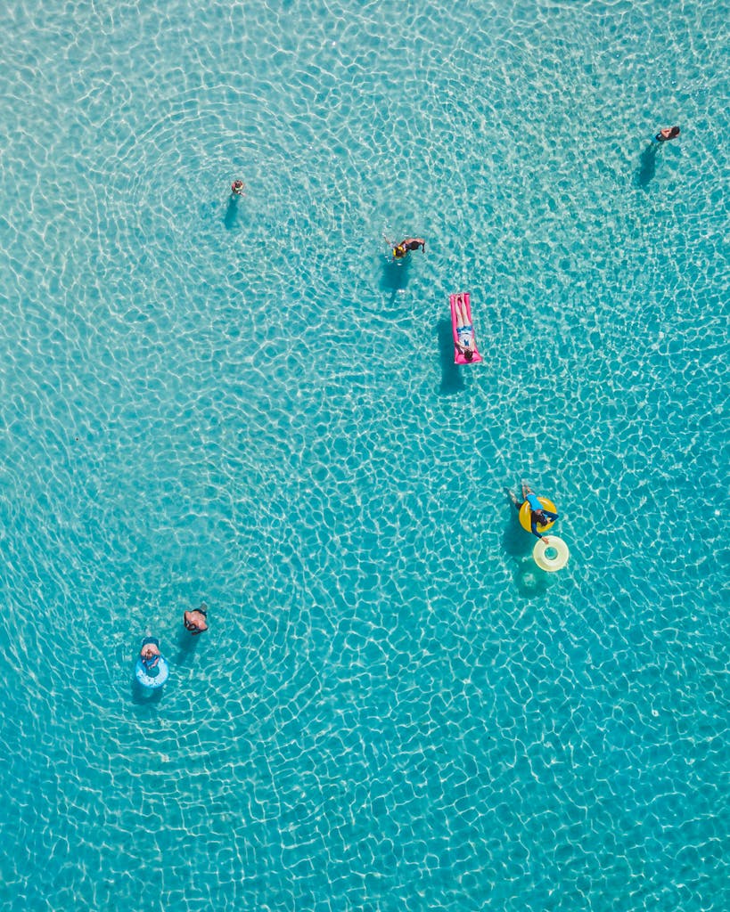 Aerial shot of people swimming and relaxing in a bright blue pool, Waimea, HI.